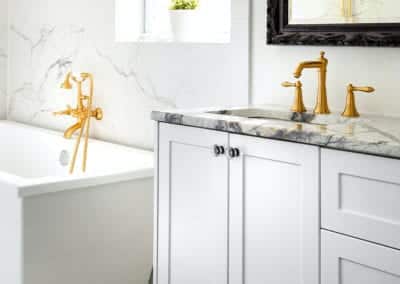 white bathroom cabinets with marble top and gold fixtures