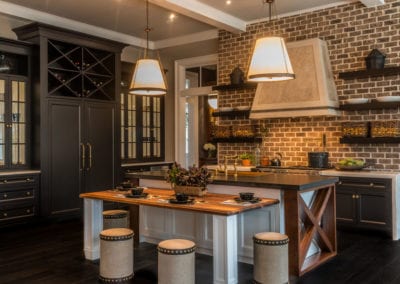 french style kitchen with dark brown cabinets and exposed brick wall
