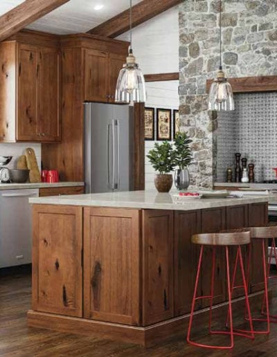 rustic kitchen with dark wood cabinets and stone wall